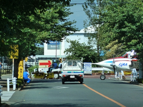 一般道を一時閉鎖して右側のJAXAハンガーから左側の調布飛行場へ